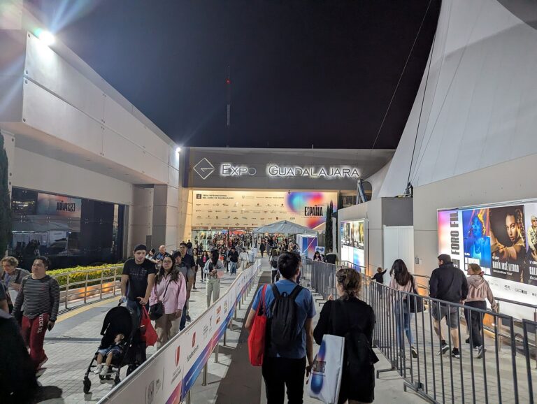 Visitantes caminan hacia la entrada de Expo Guadalajara durante la FIL Guadalajara de 2024, de noche